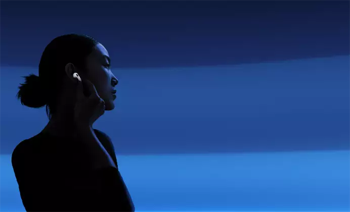 A person with their thumb and pointer finger holding the stem of their AirPods 5 to change listening modes