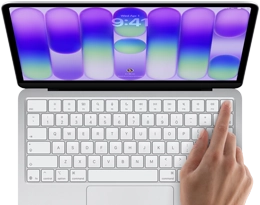 MacBook Neo, silver color, showing login screen, person's finger on Touch ID sensor in top-right corner of keyboard