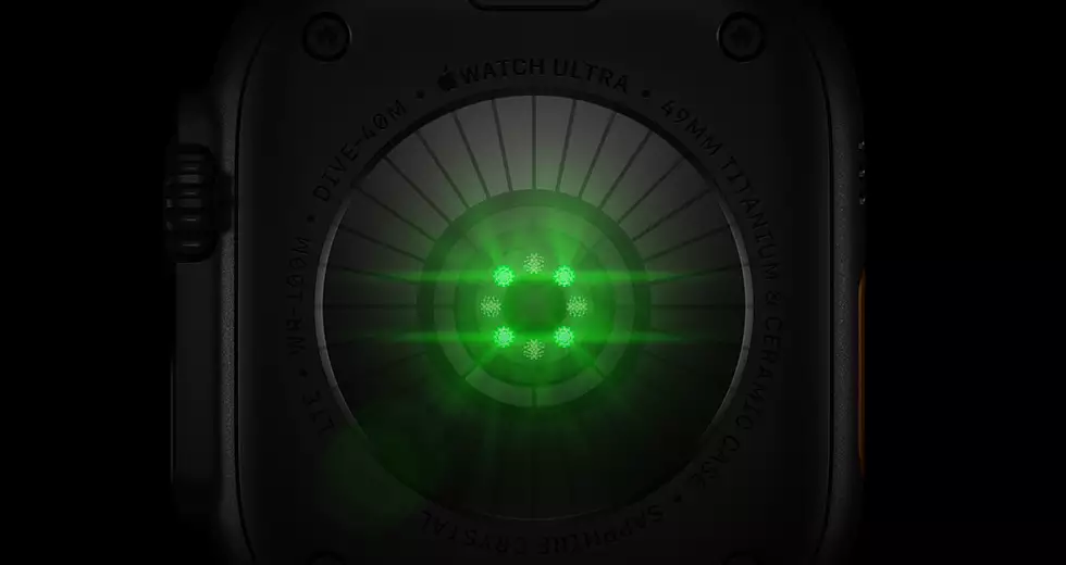 Back of Apple Watch Ultra 4, titanium case, black color, multiple round sensors with glowing green LED lights