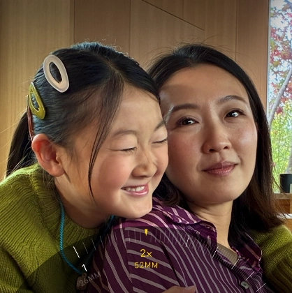 2x Telephoto feature in use, zooming in on two people hugging