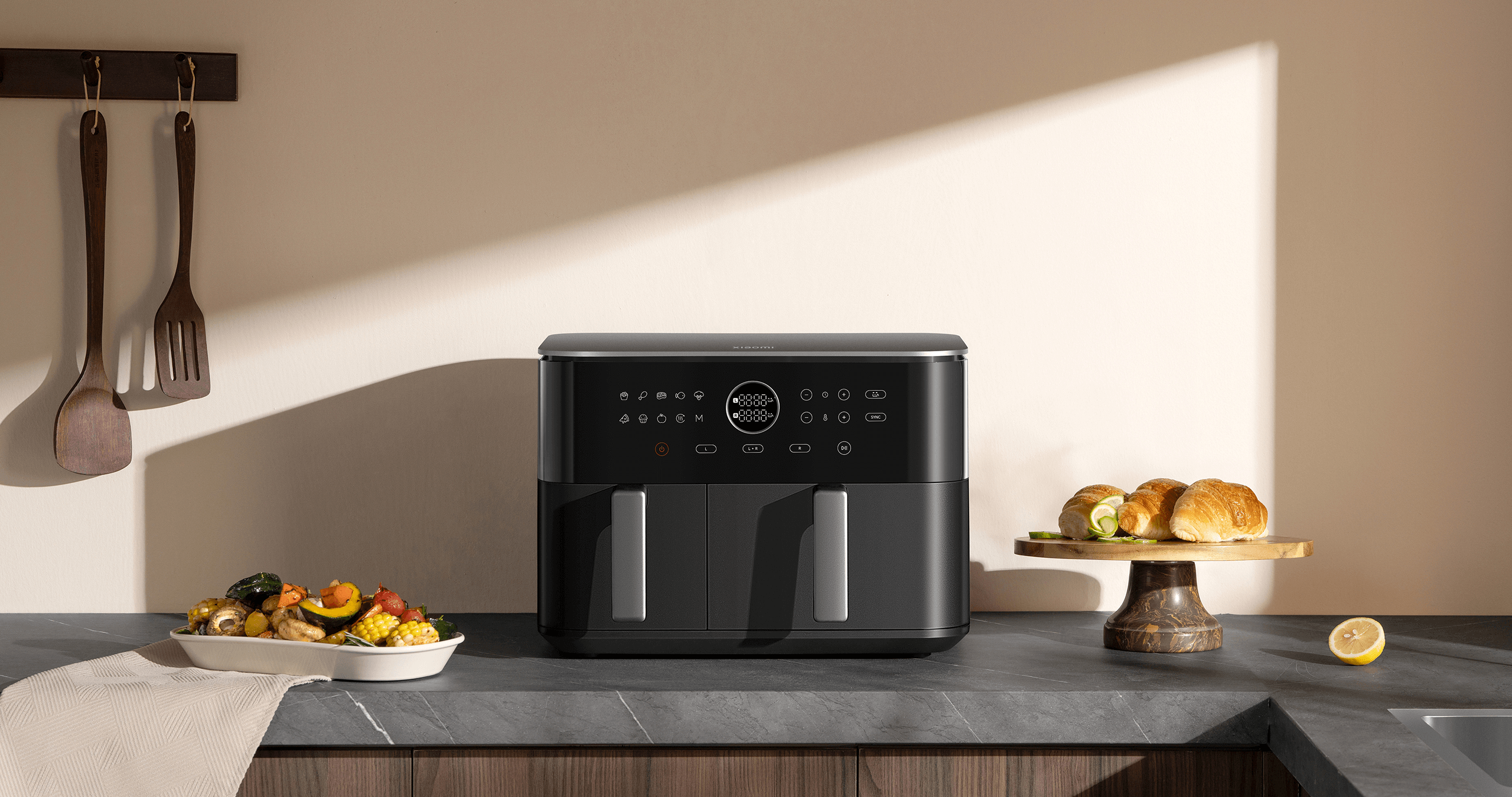 Еър фрайер Xiaomi Dual Zone Air Fryer 10L върху кухненски плот с приготвени ястия