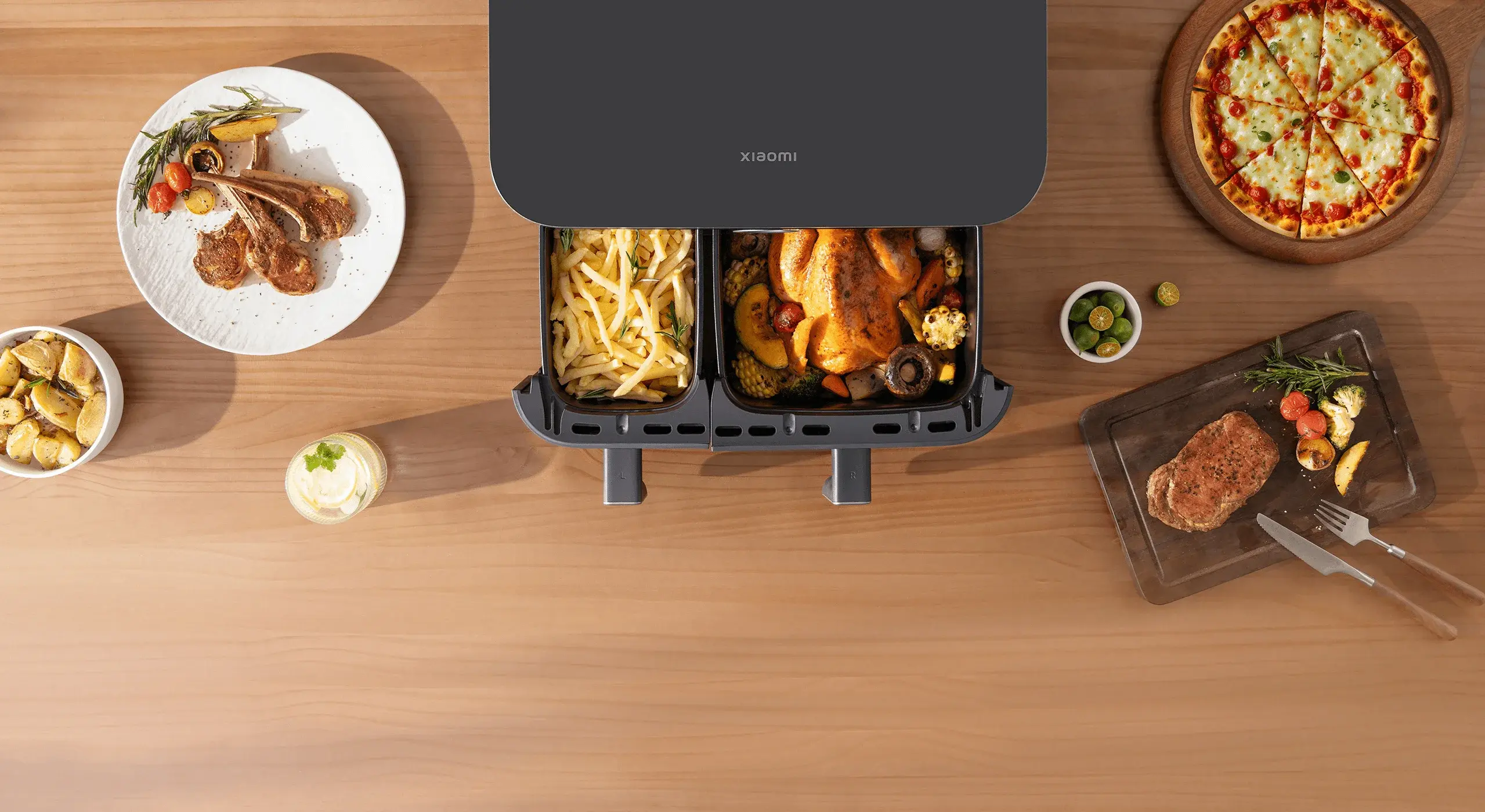 Двете кошници на Xiaomi Dual Zone Air Fryer 10L с картофки и печено пиле, заобиколени от ястия