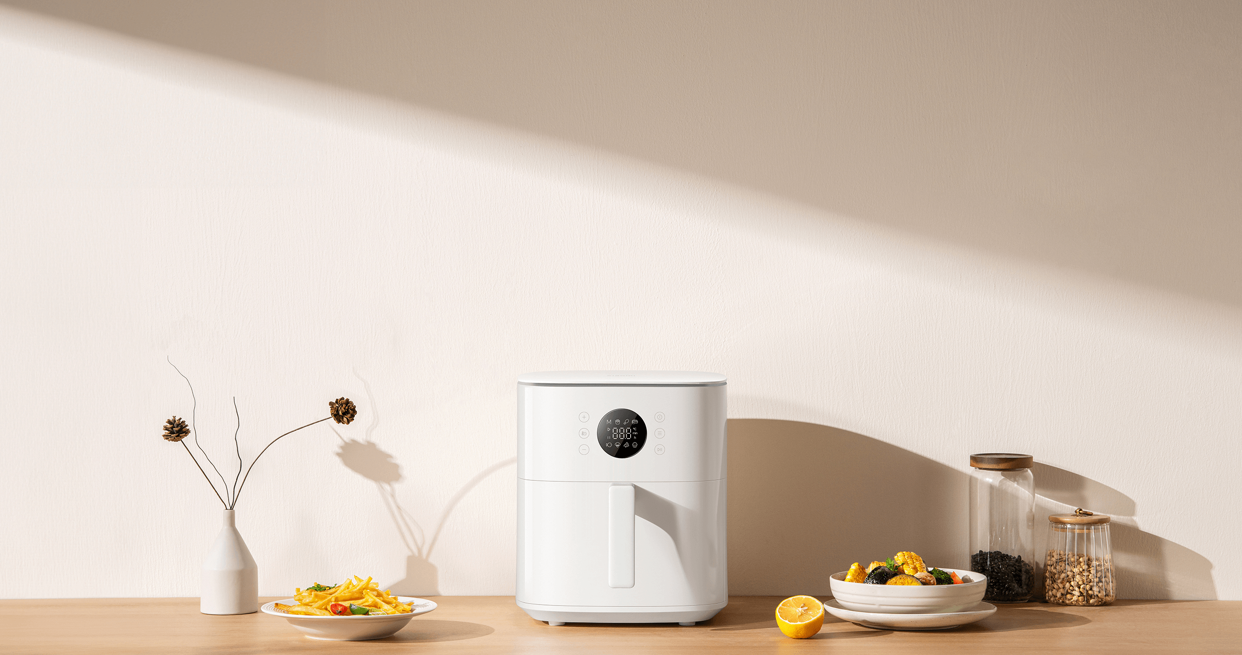 Xiaomi Air Fryer 6.5L в бяло върху кухненски плот до чиния с картофи и купа със зеленчуци