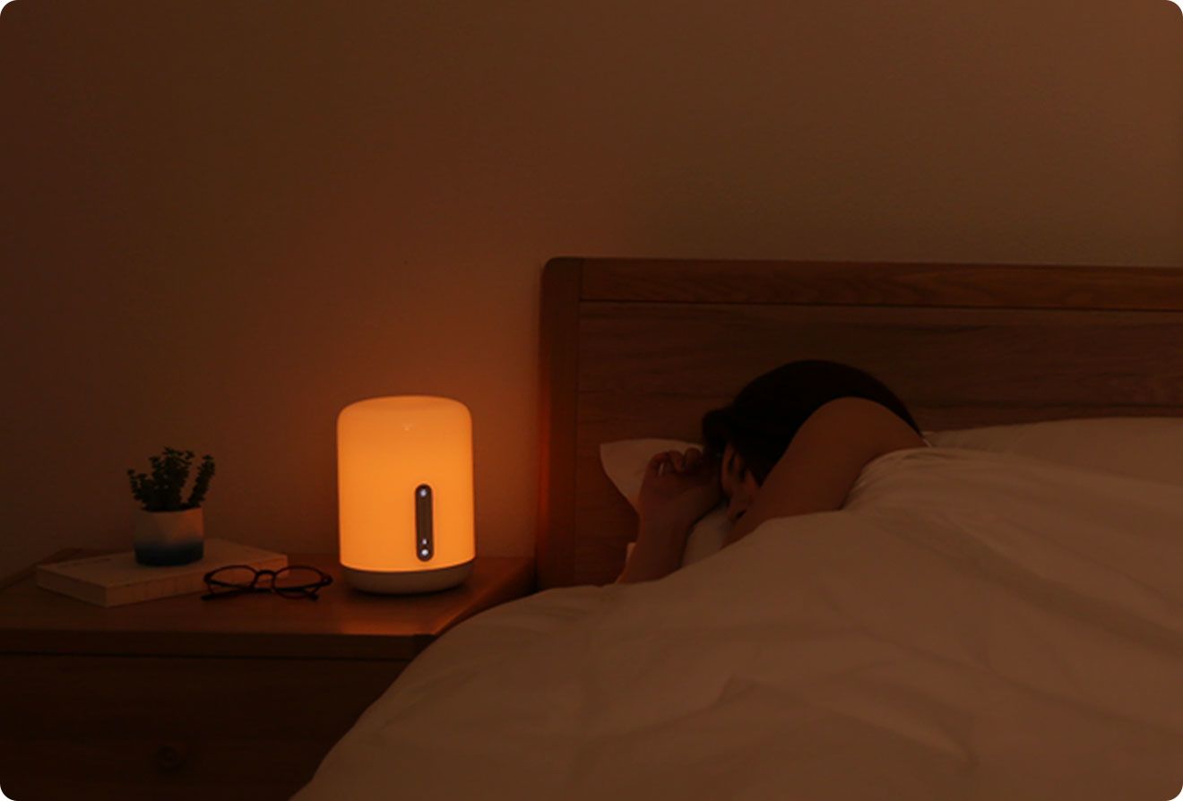 Жена почива до Mi Bedside Lamp 2 с мека нощна светлина