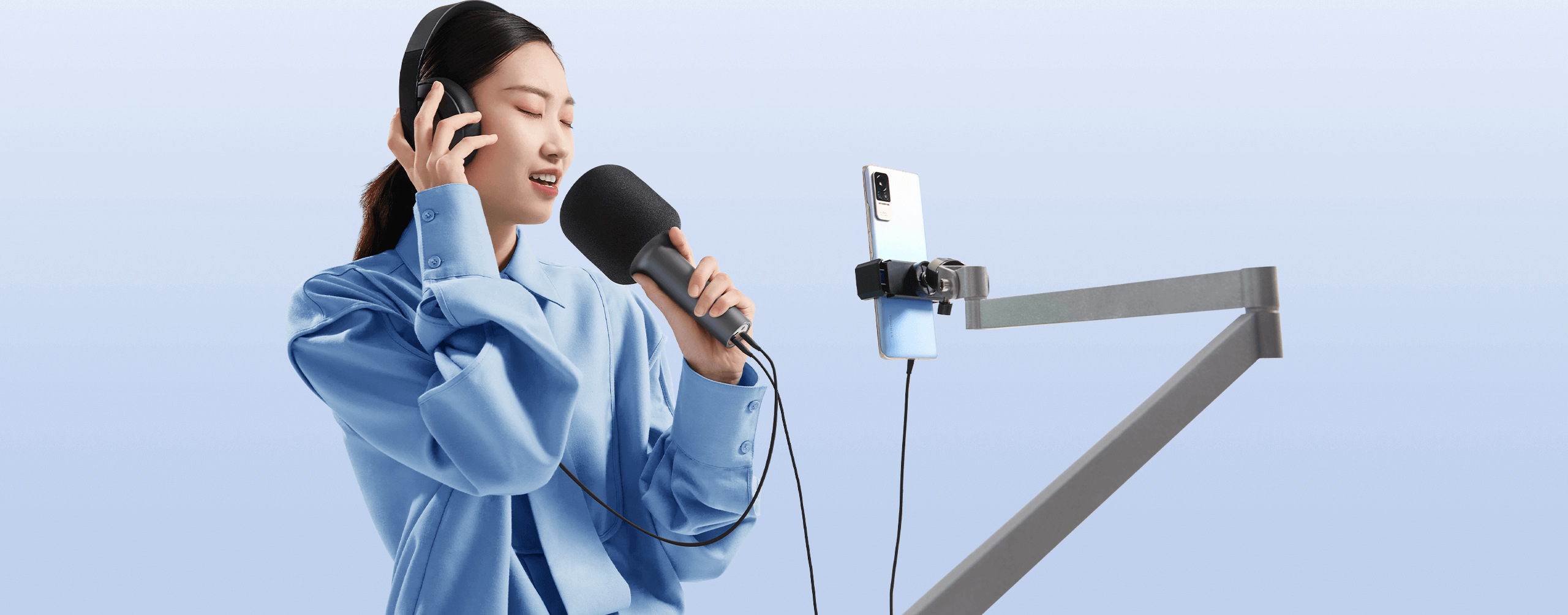Момиче със слушалки записва с Xiaomi Karaoke Microphone и смартфон