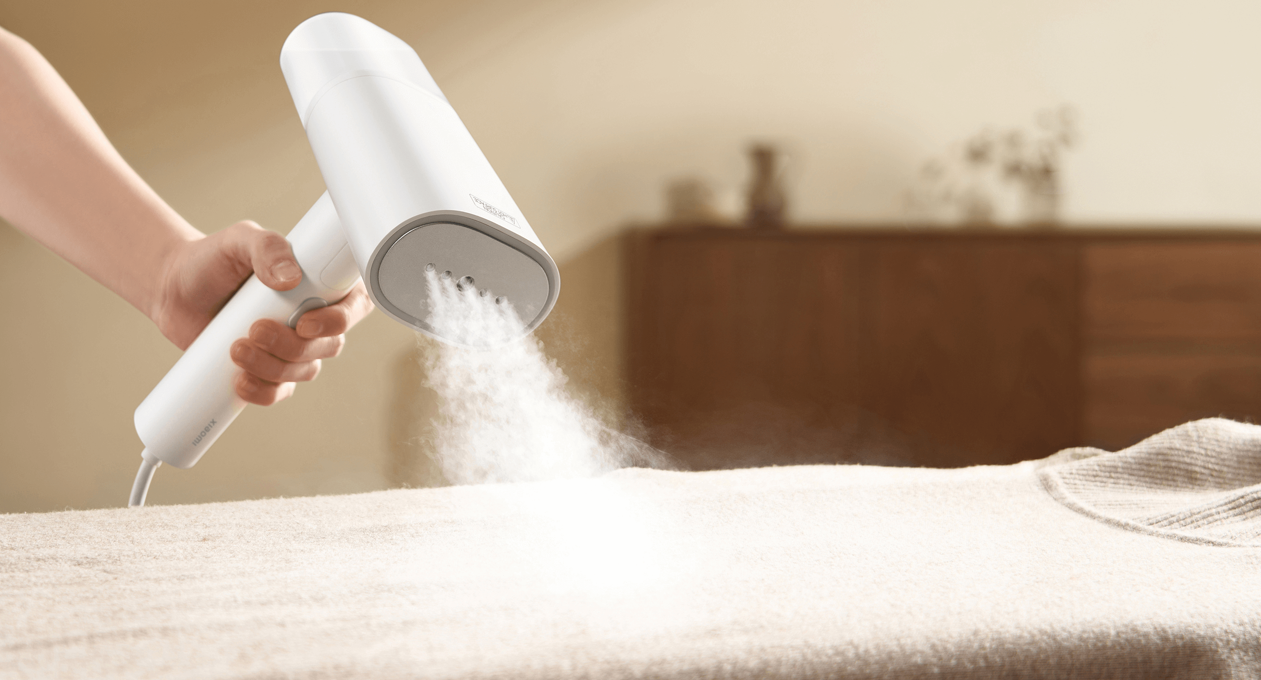 Мощна струя пара от Xiaomi Handheld Garment Steamer върху разстлана дреха
