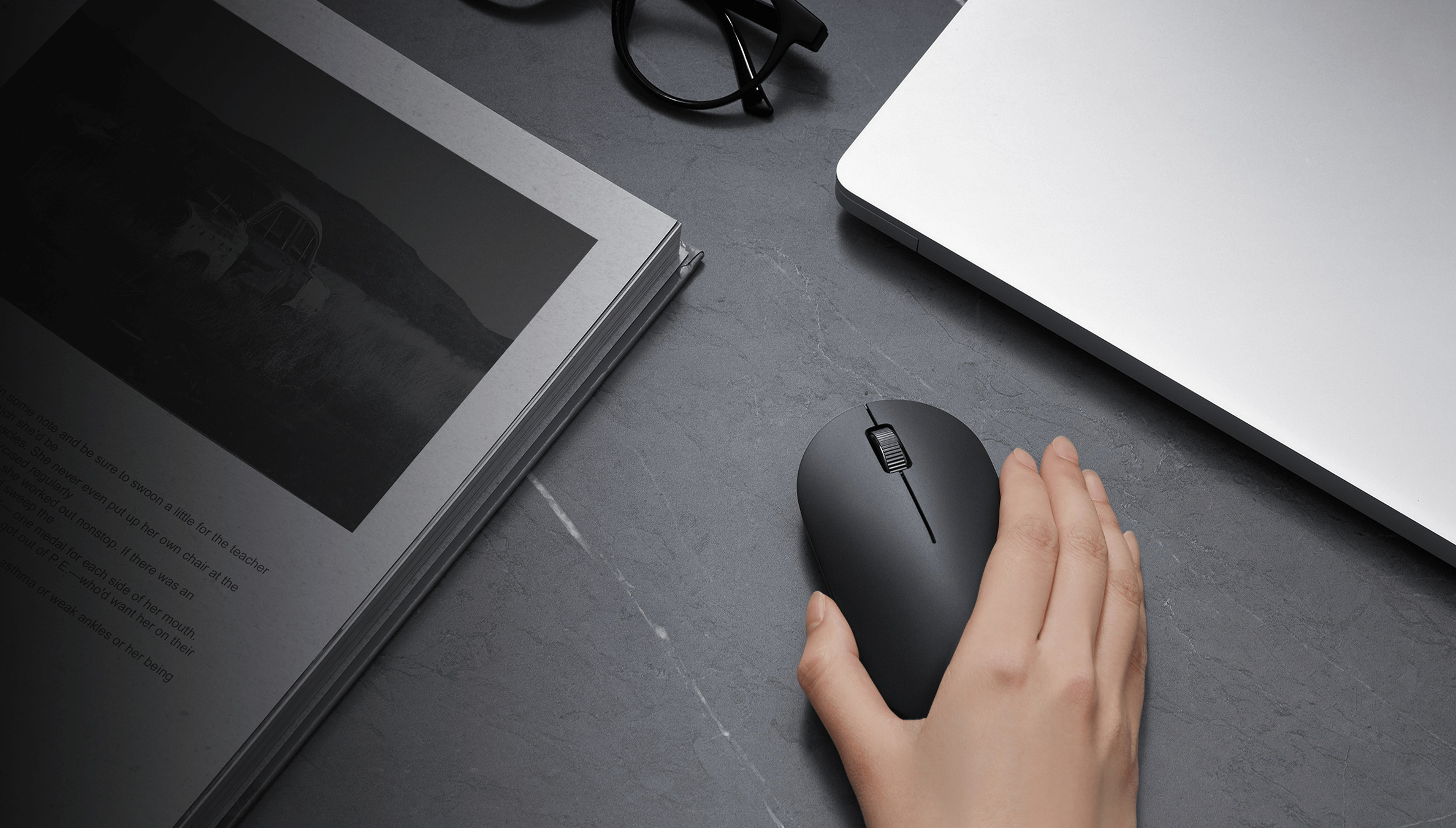 Xiaomi Wireless Mouse Lite 2 в употреба до лаптоп върху тъмно бюро