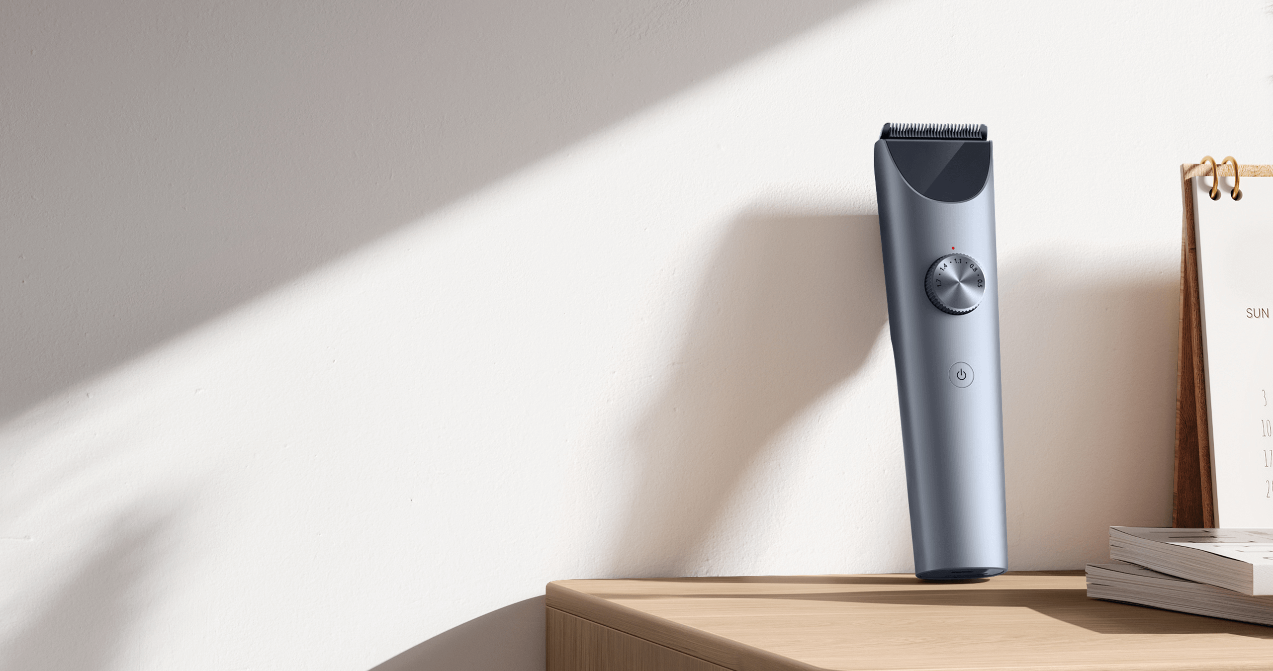 Машинка за подстригване Xiaomi Hair Clipper 2, поставена на дървен рафт