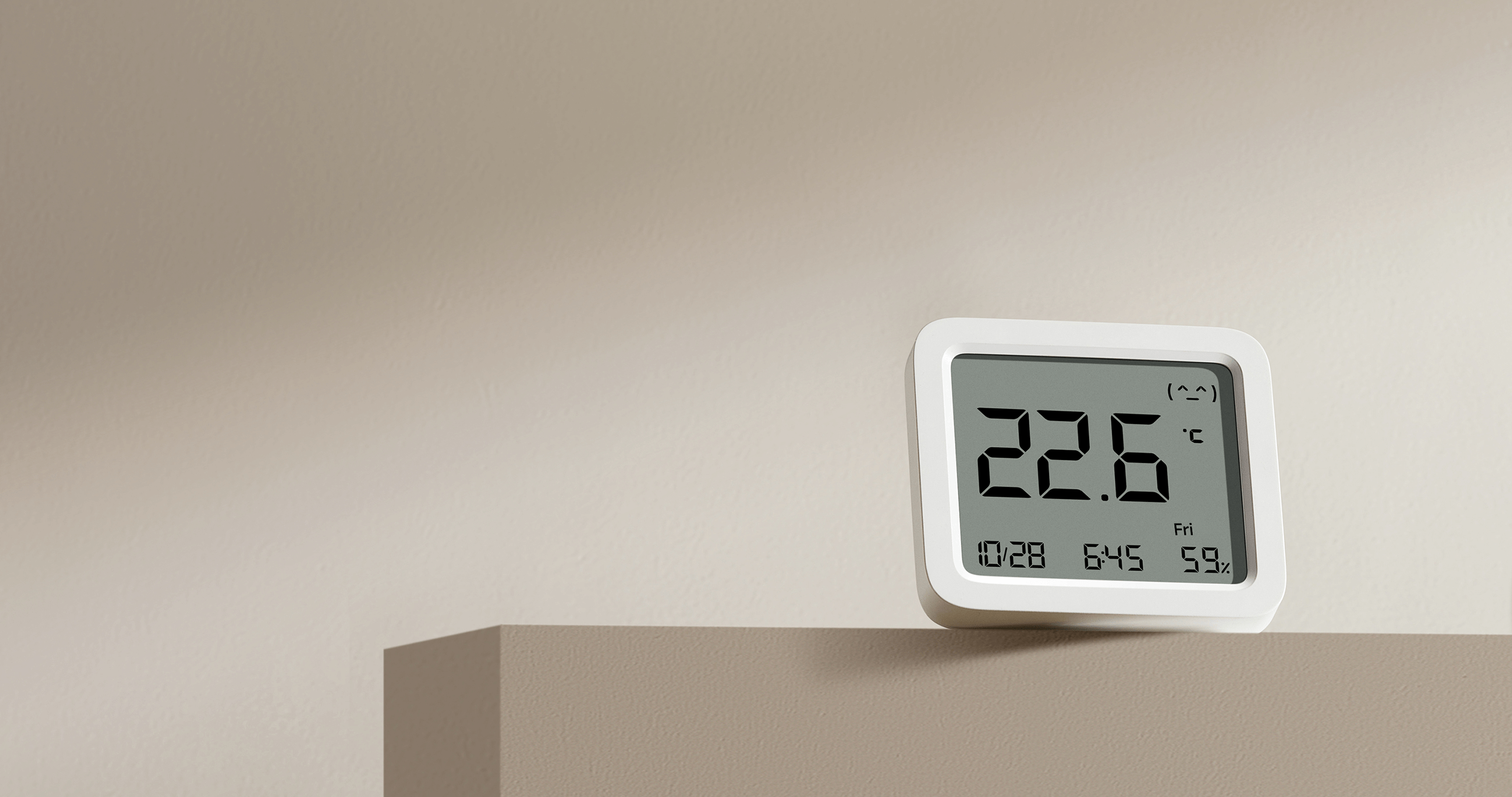 Термометър-хигрометър Xiaomi Smart Temperature and Humidity Monitor 3 върху рафт в дневната