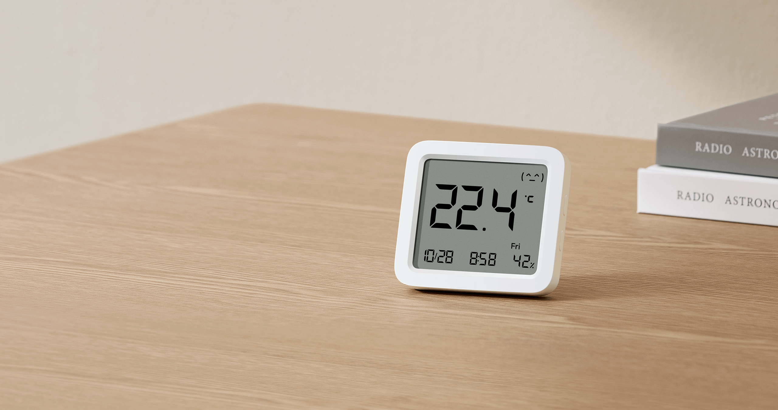 Xiaomi Smart Temperature and Humidity Monitor 3 на бюро показва емотикон за ниво на комфорт