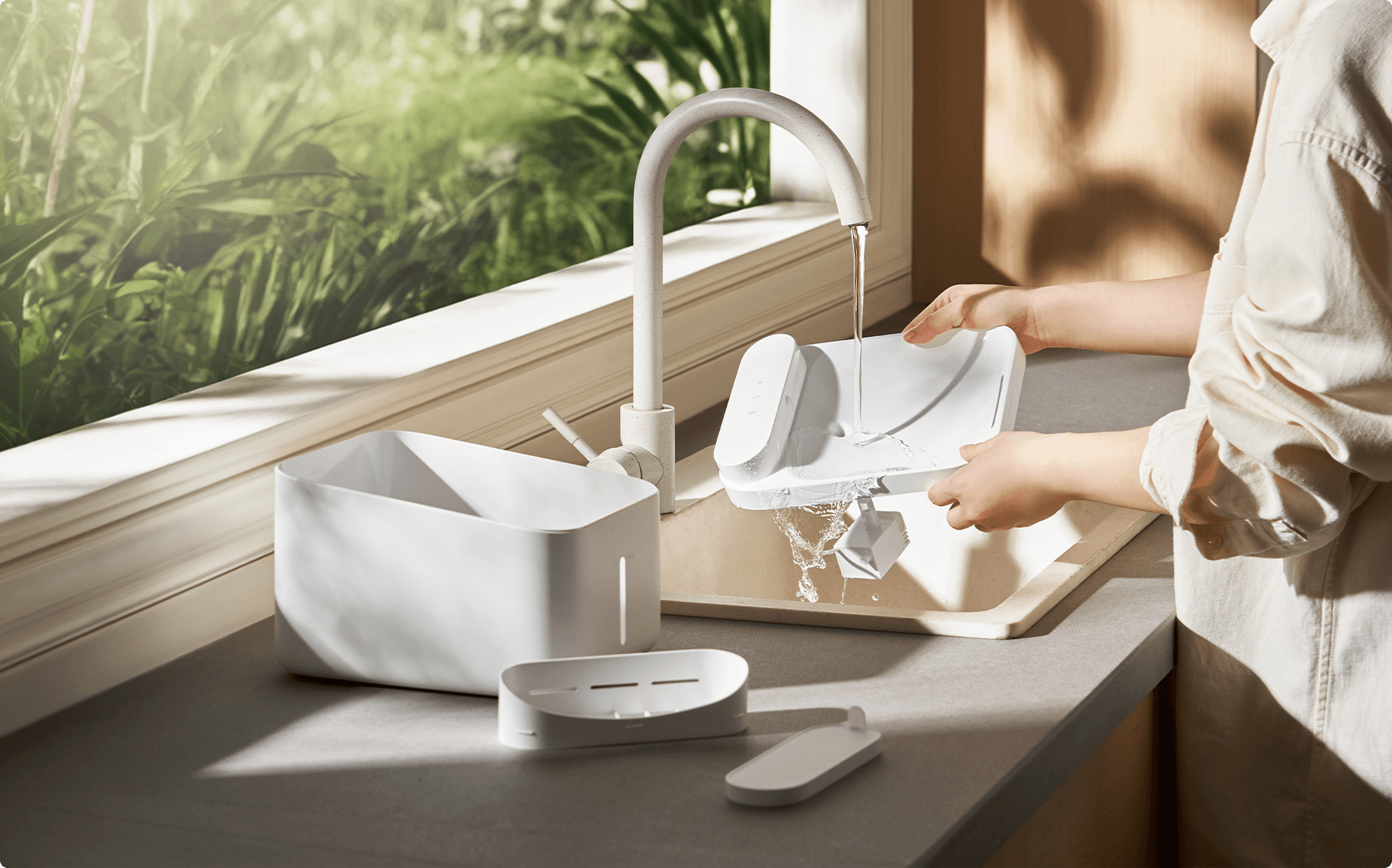 Изплакване на разглобения Xiaomi Smart Pet Fountain 2 под течаща вода в мивка