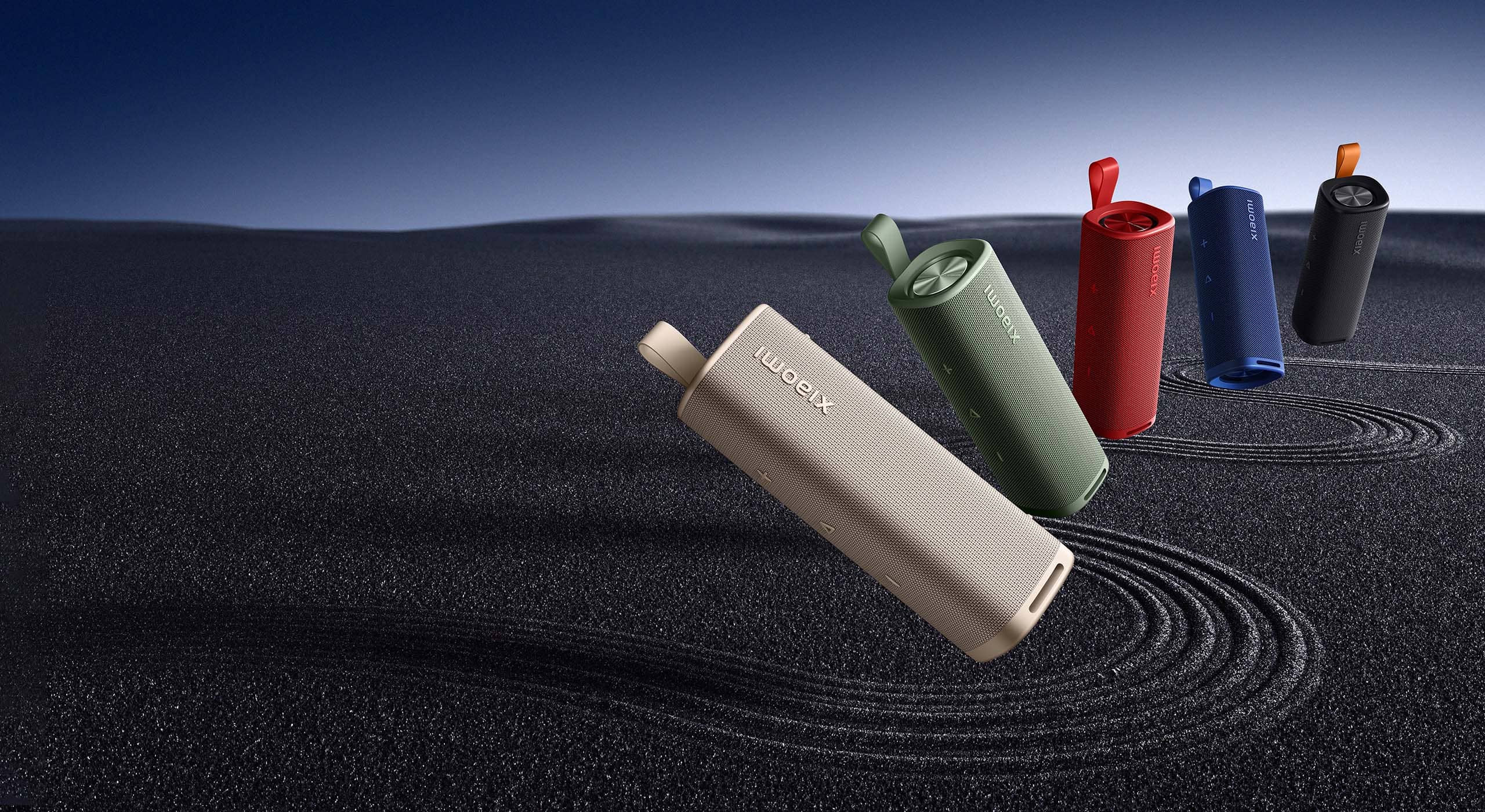 Портативна колонка Xiaomi Sound Outdoor 30W в пет цвята върху тъмен пясъчен пейзаж