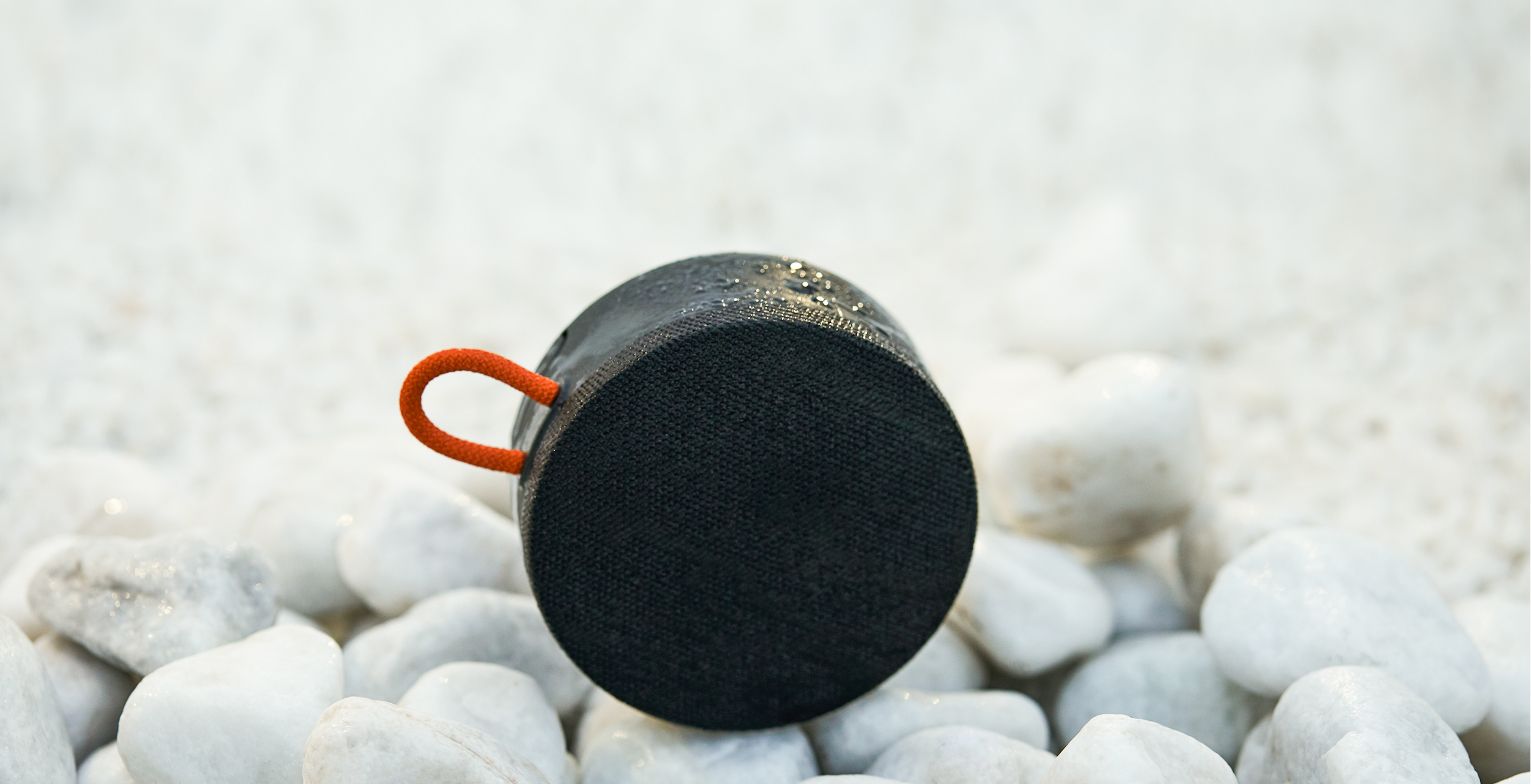 Mi Portable Bluetooth Speaker с водни капки върху бели речни камъни