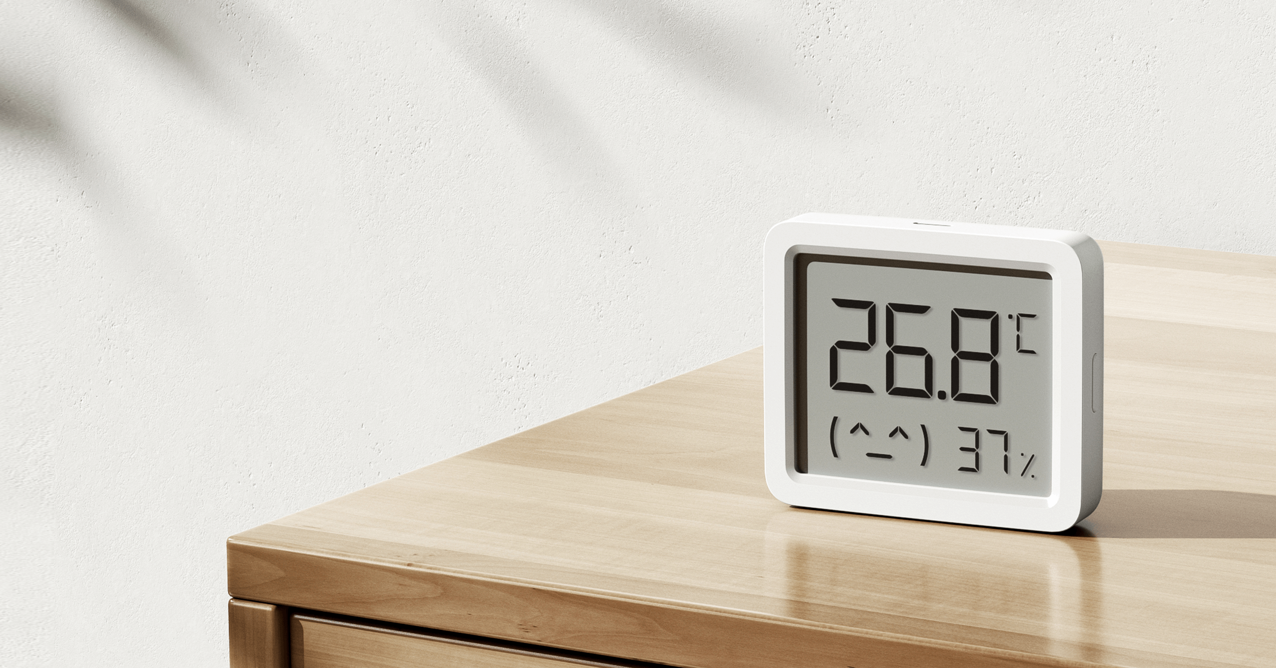 Термометър-хигрометър Xiaomi Smart Temperature and Humidity Monitor 3 Mini върху дървен скрин в дневната