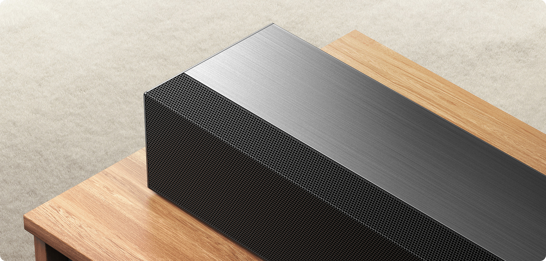 Близък план на четканата метална мрежа на саундбар Xiaomi Soundbar Pro 2.0 ch NS5 върху дървена маса